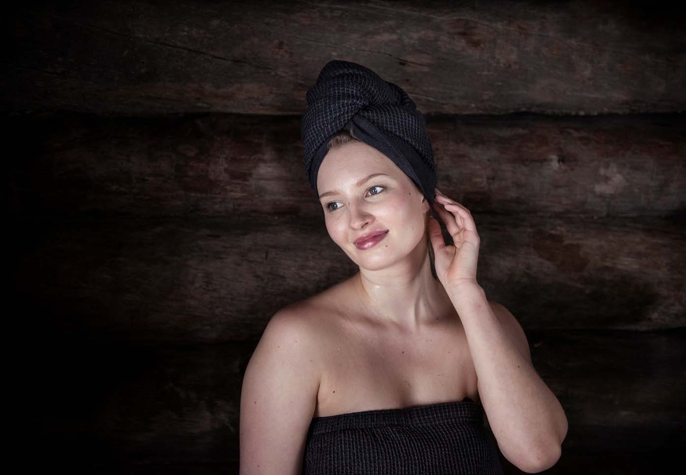 Woman in a sauna with a hair towel