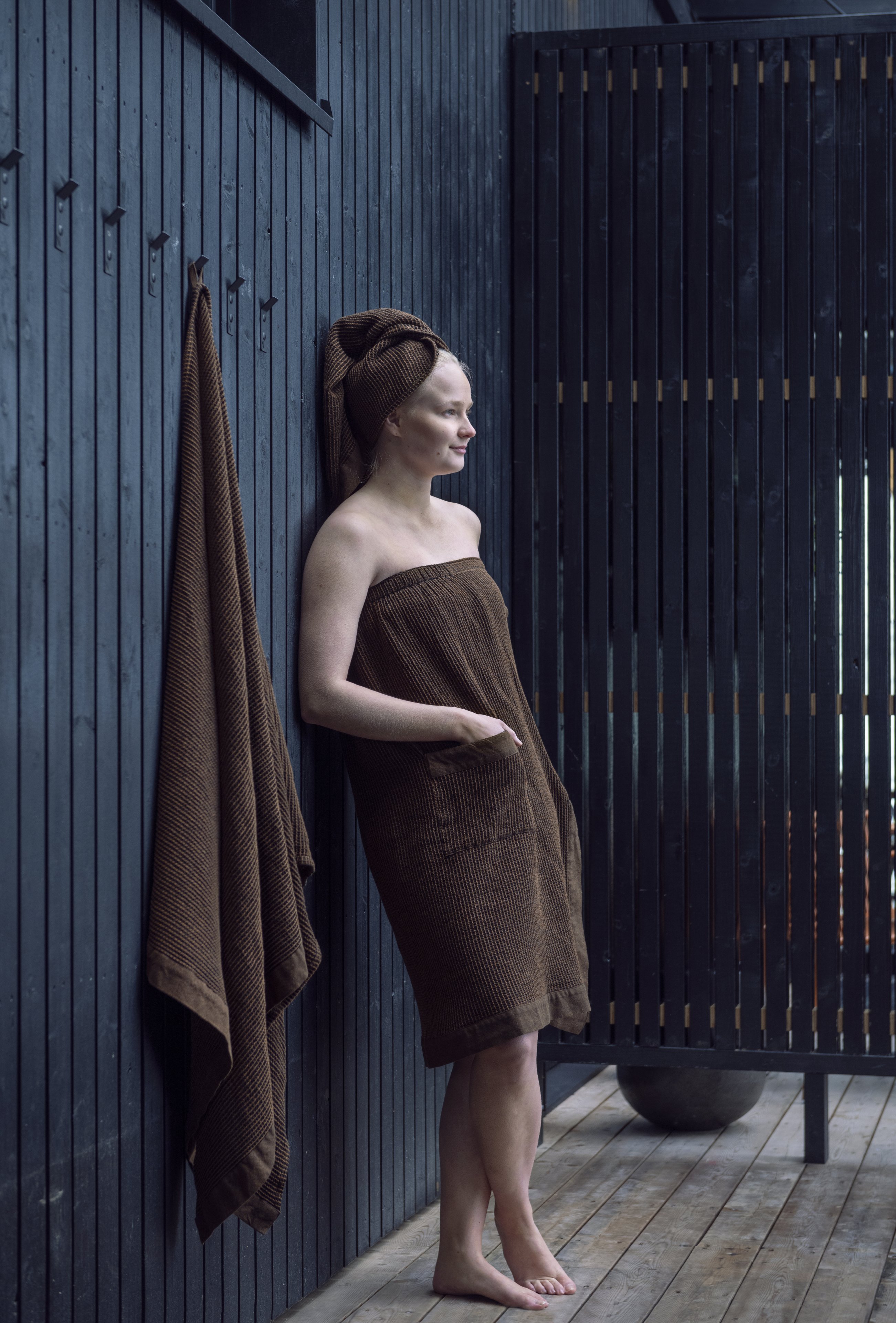 Woman wearing sauna apron and hair towel