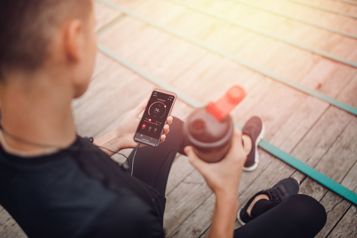 athlete holding a water bottle and phone