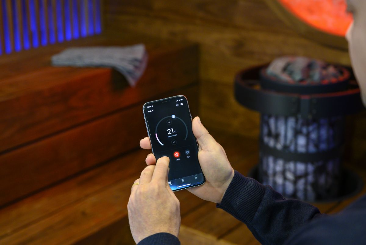 person controlling sauna equipment with the MyHarvia mobile app